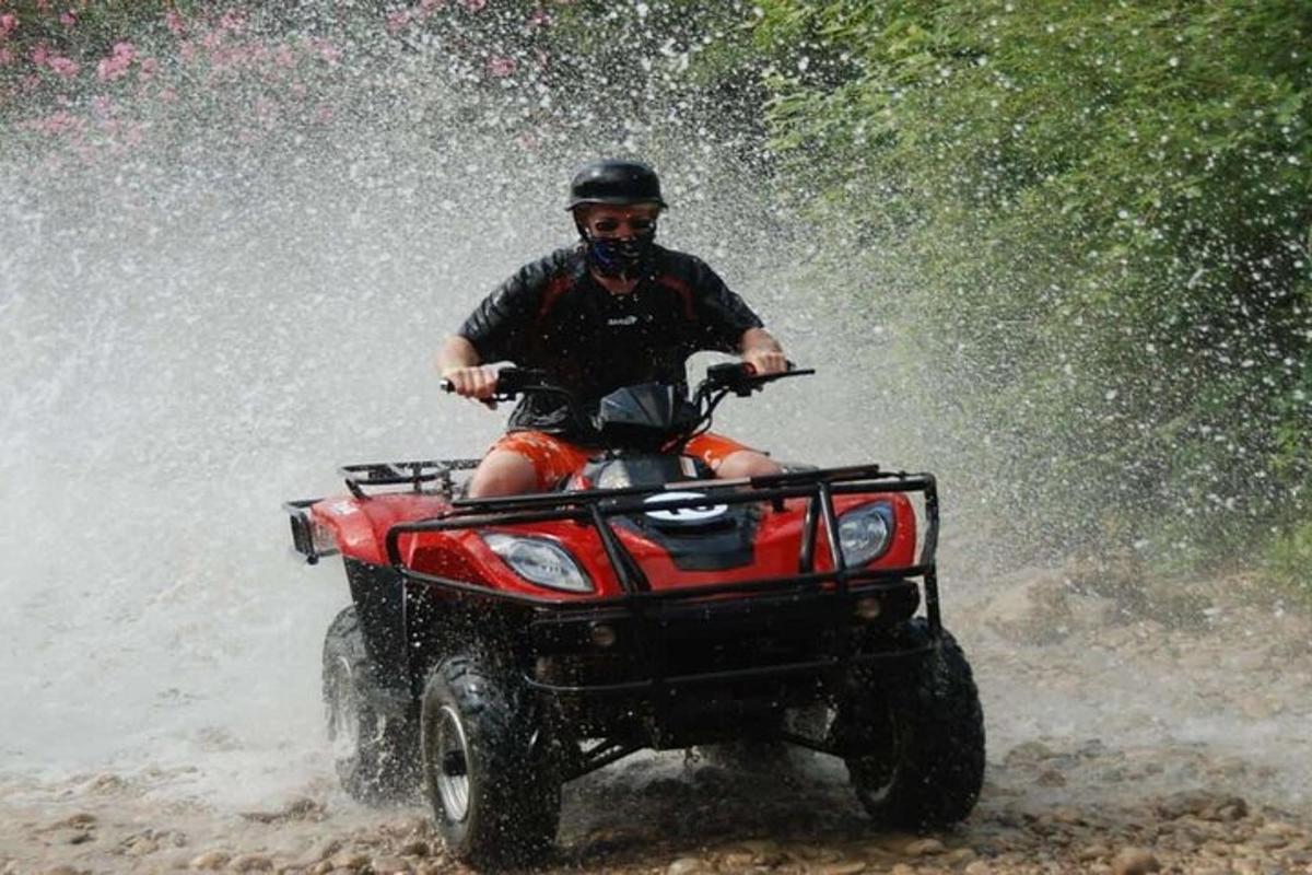 un uomo che guida un quad nel fango