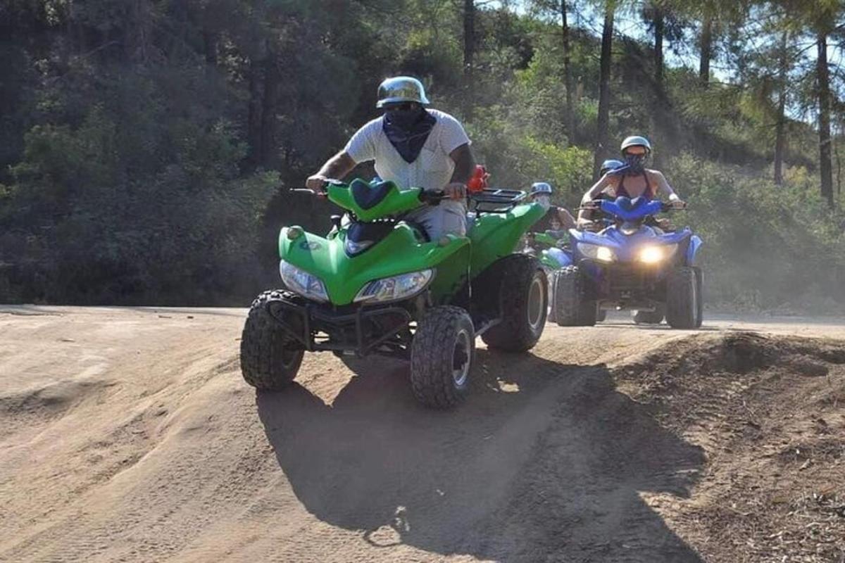 dua orang mengendarai ATV di jalan tanah