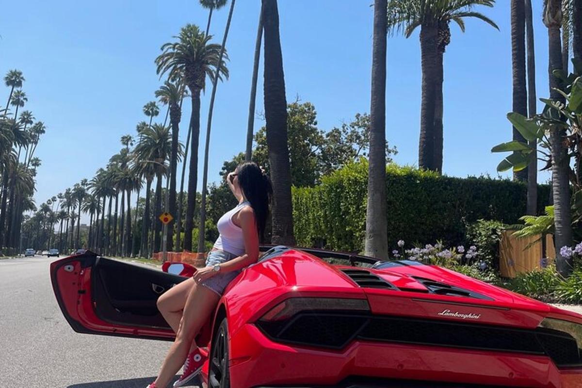 žena sedící na kapotě červeného Lamborghini