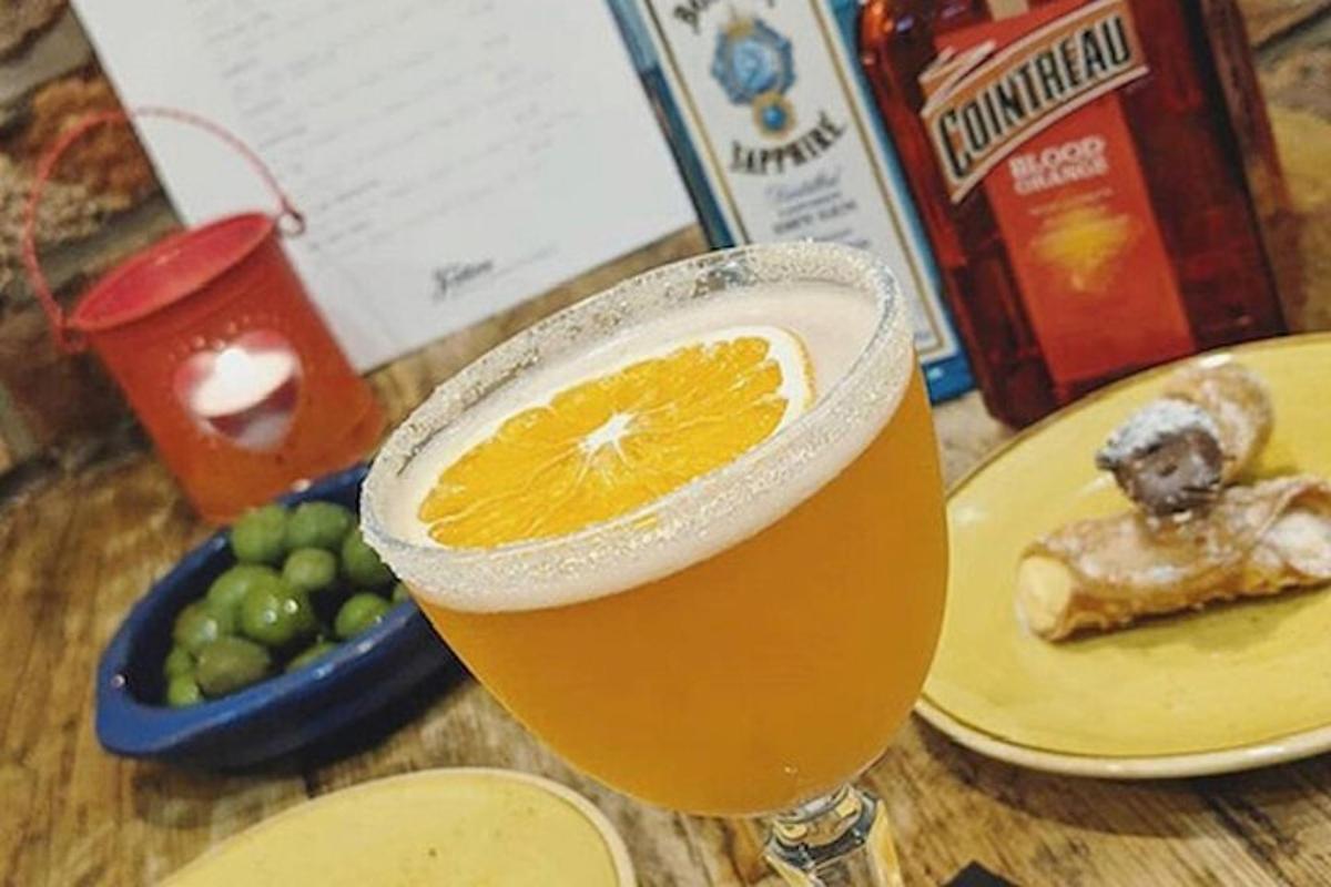Un vaso de cerveza con una rodaja de naranja sobre una mesa