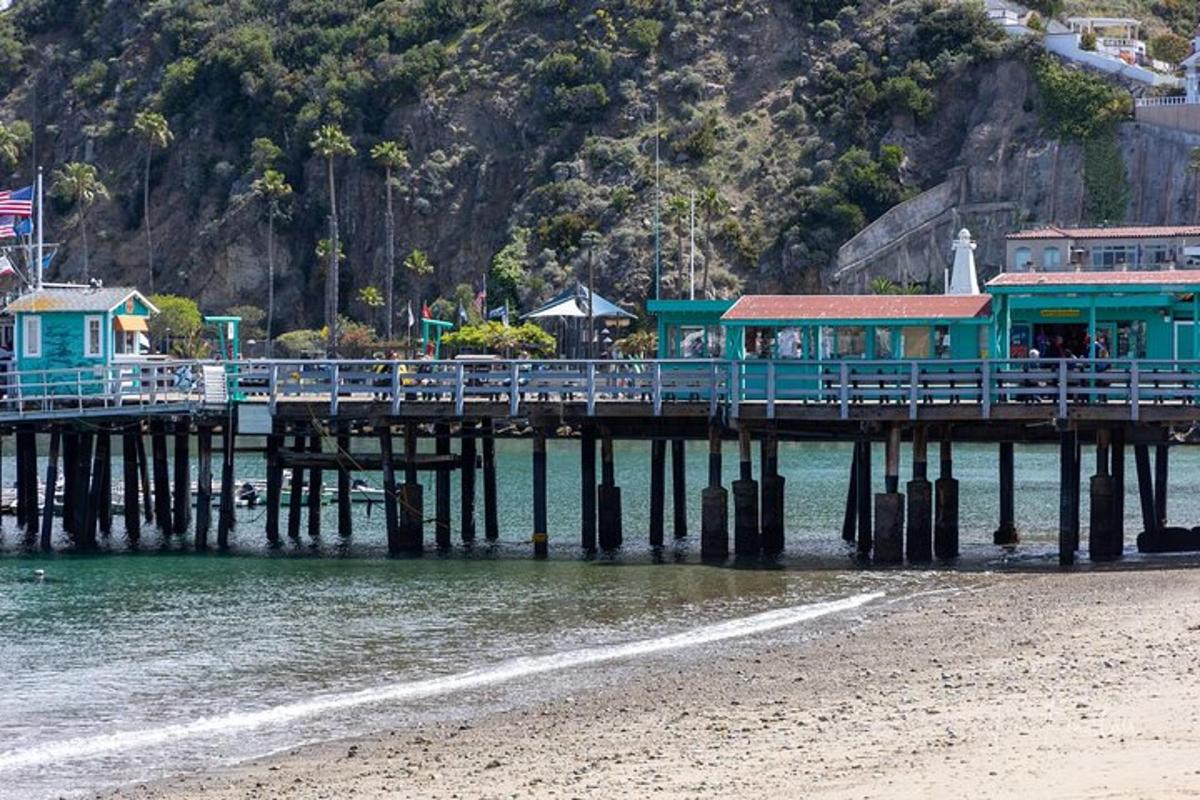 a pier on the water next to a beach