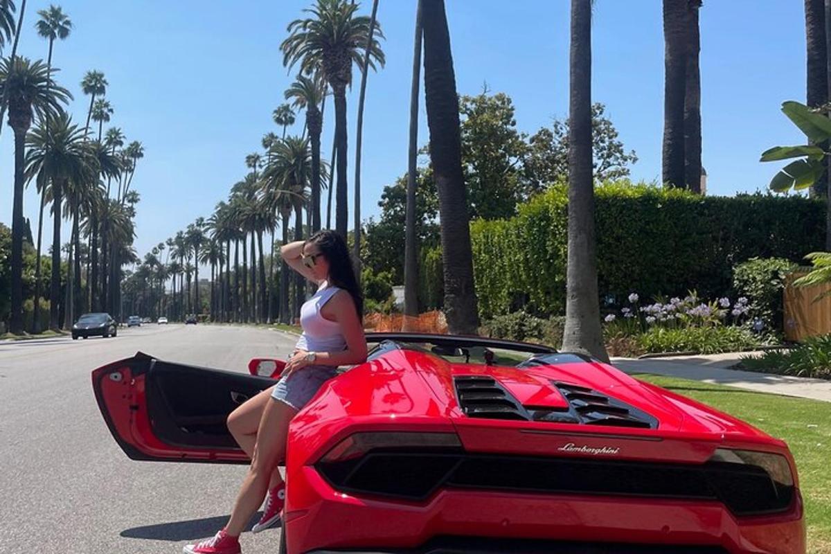 žena sedící na kapotě červeného Lamborghini