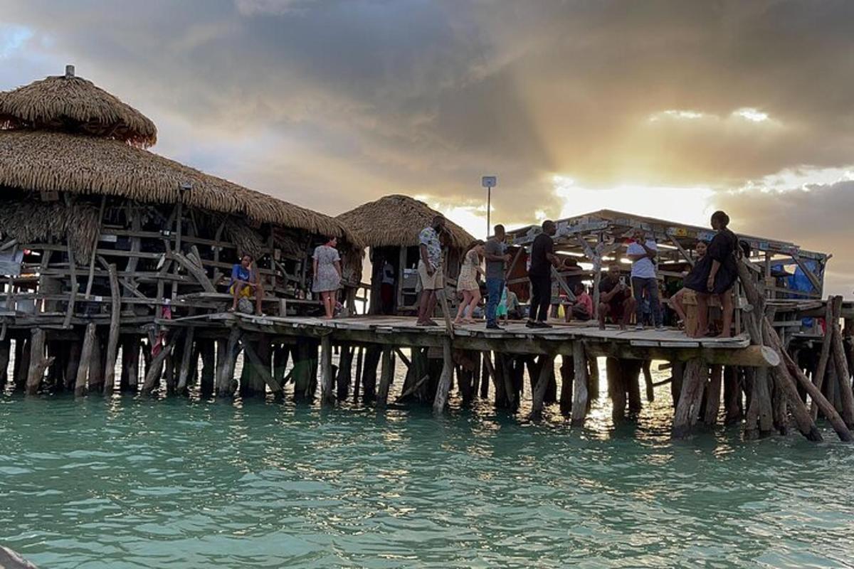 a group of people standing on a pier in the water