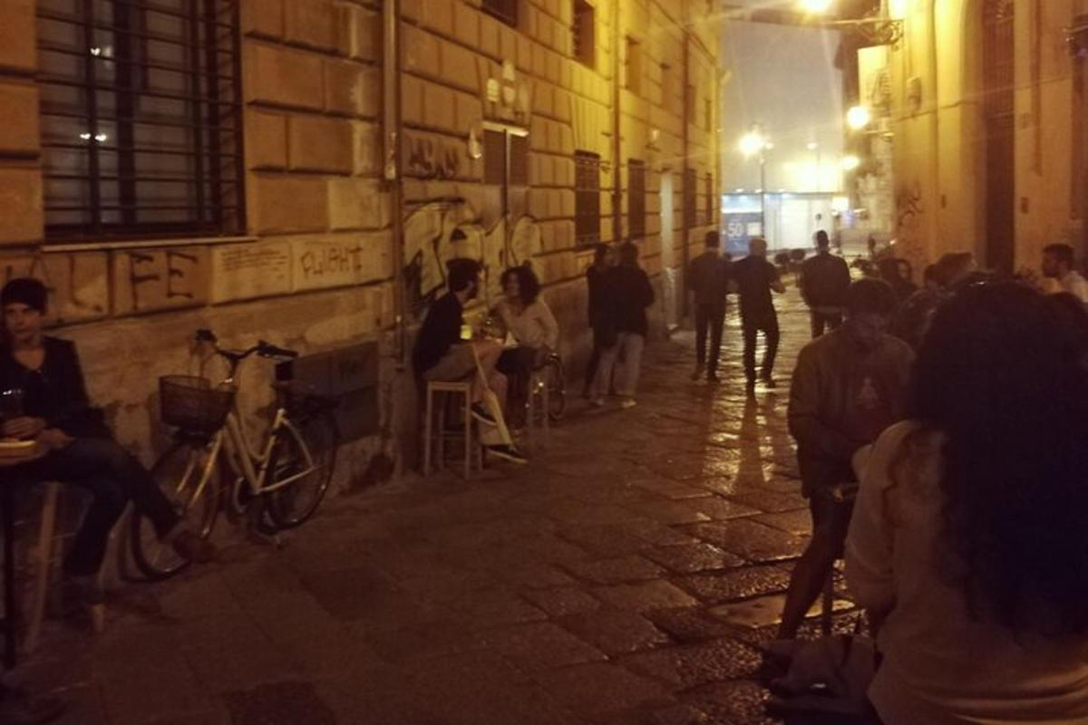 skupina lidí sedících v noci na ulici