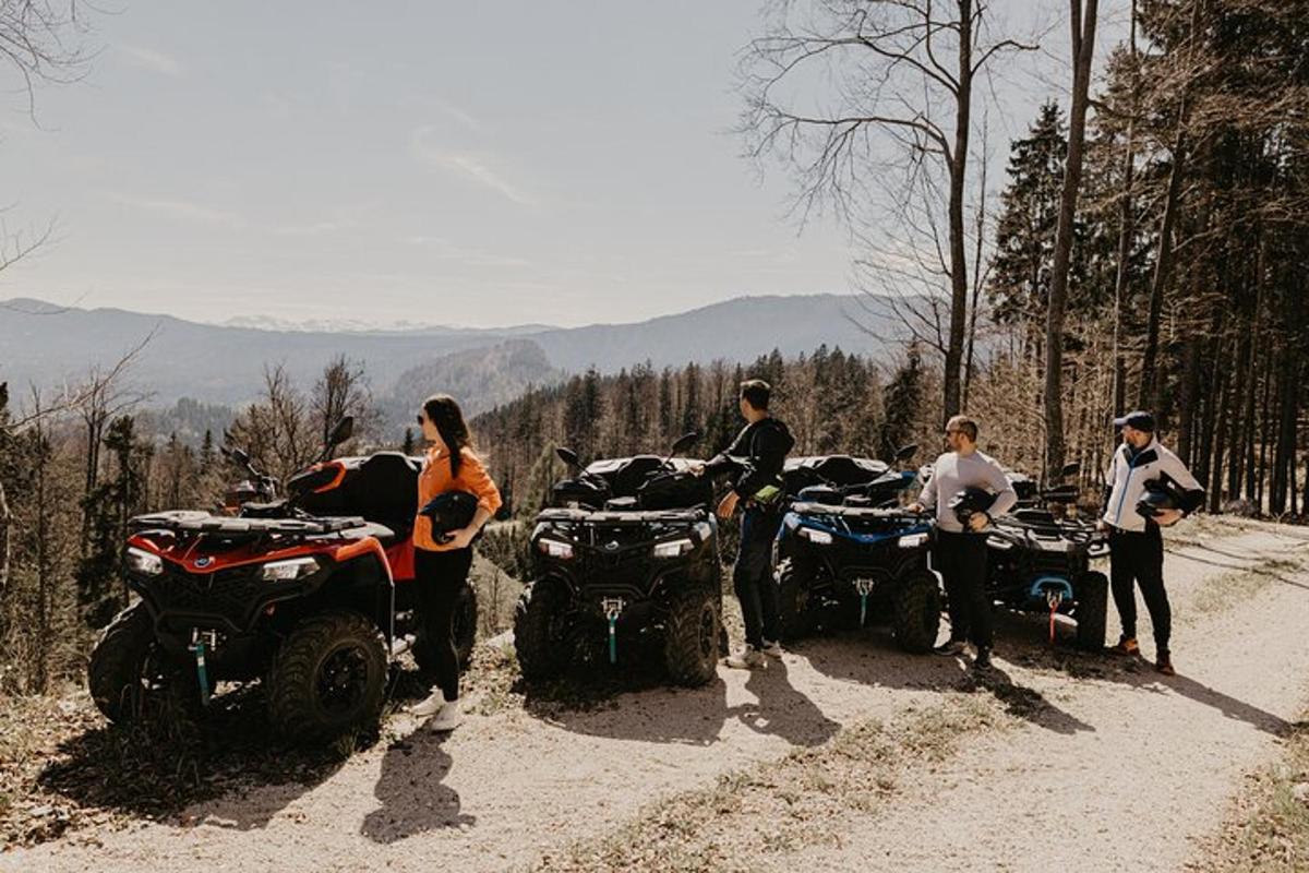 a group of people standing around atvs on a dirt road