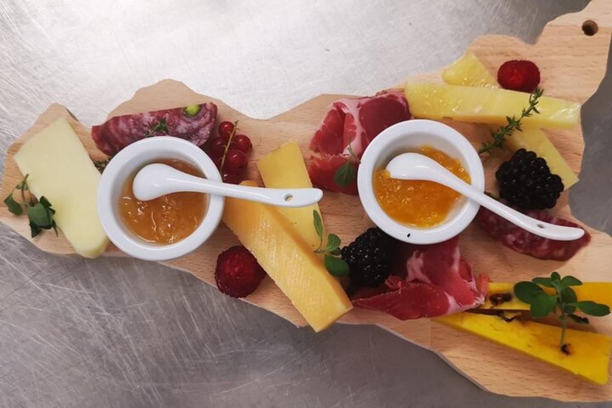 um prato de queijo e frutas em uma tábua de corte
