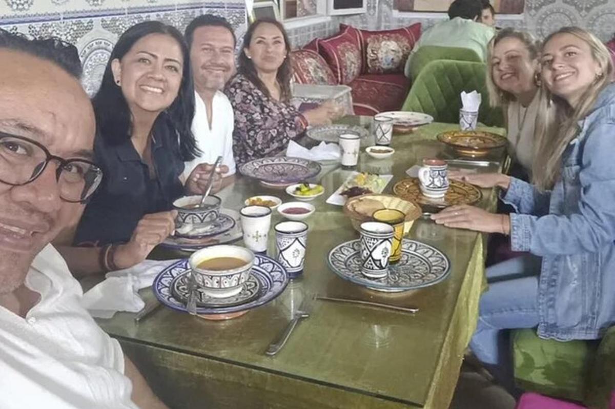 un gruppo di persone sedute attorno a un tavolo con tazze di caffè