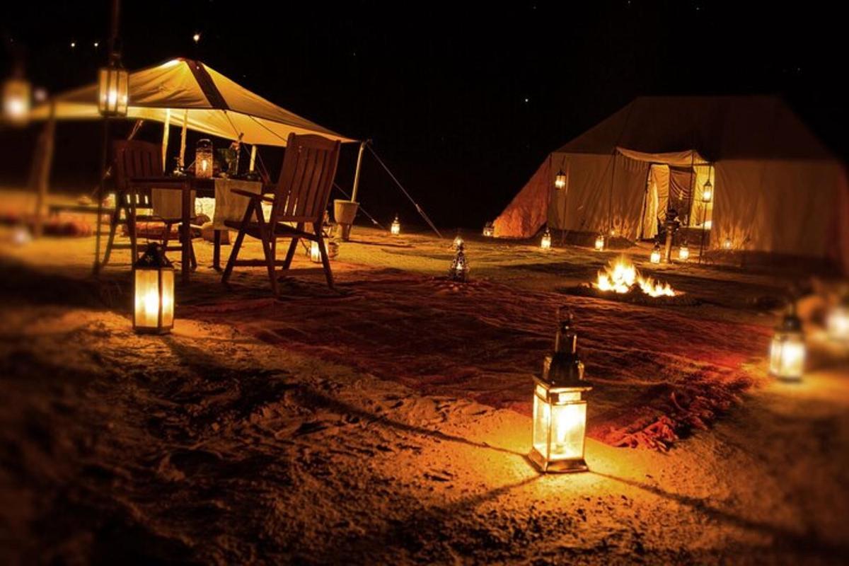 une tente avec des lumières dans le sable la nuit