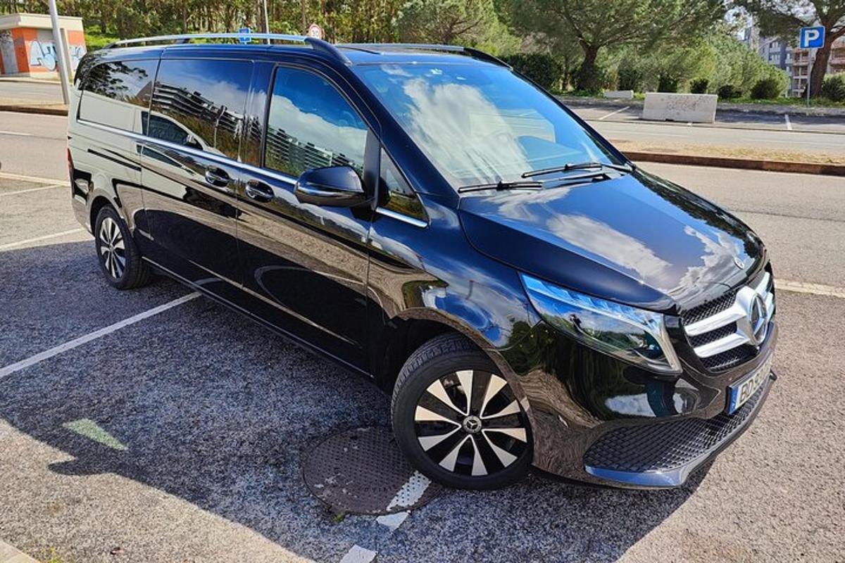 en svart skåpbil parkerad på en parkeringsplats