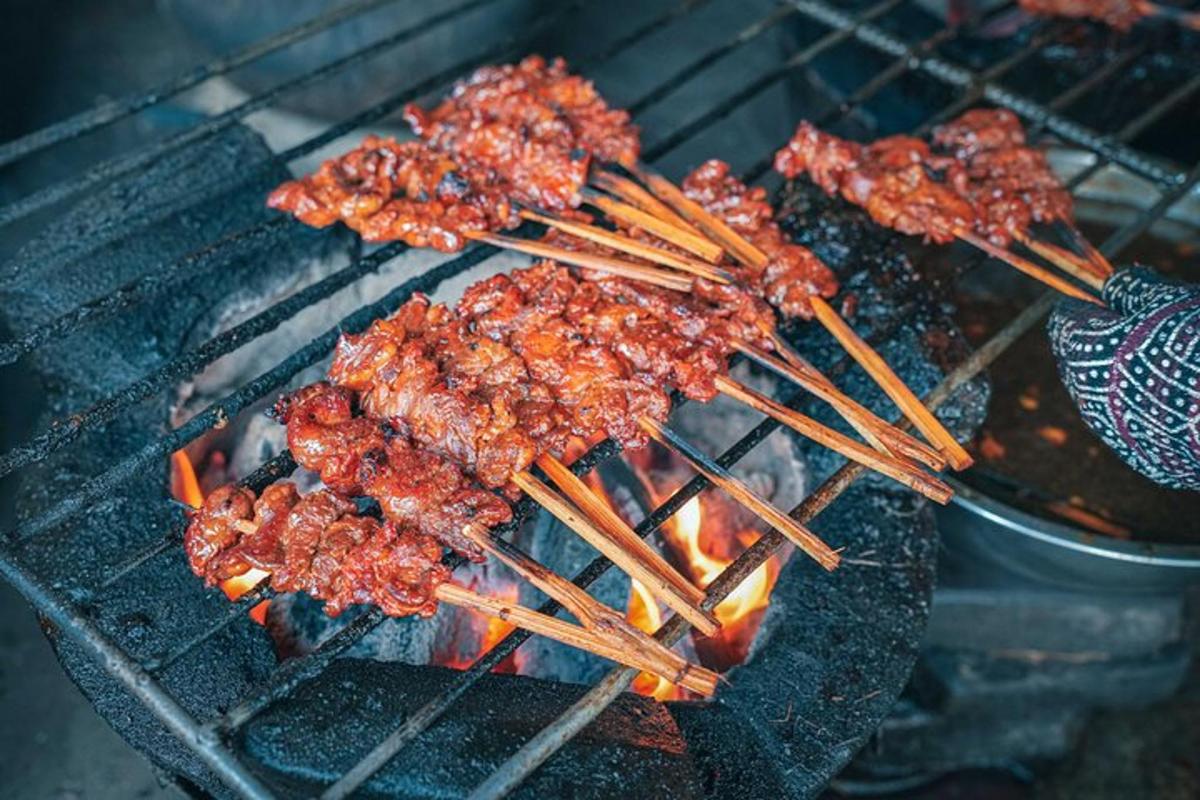 a group of skewers cooking food on a grill