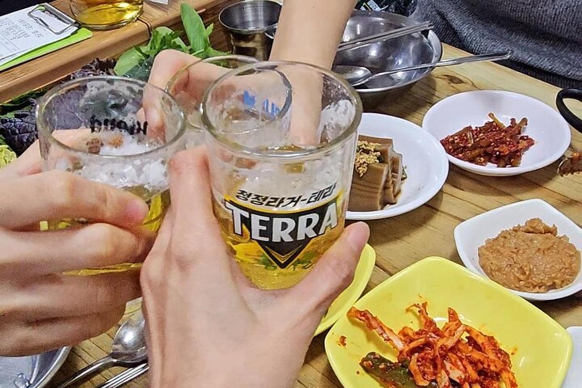 una persona che tiene un bicchiere di birra su un tavolo