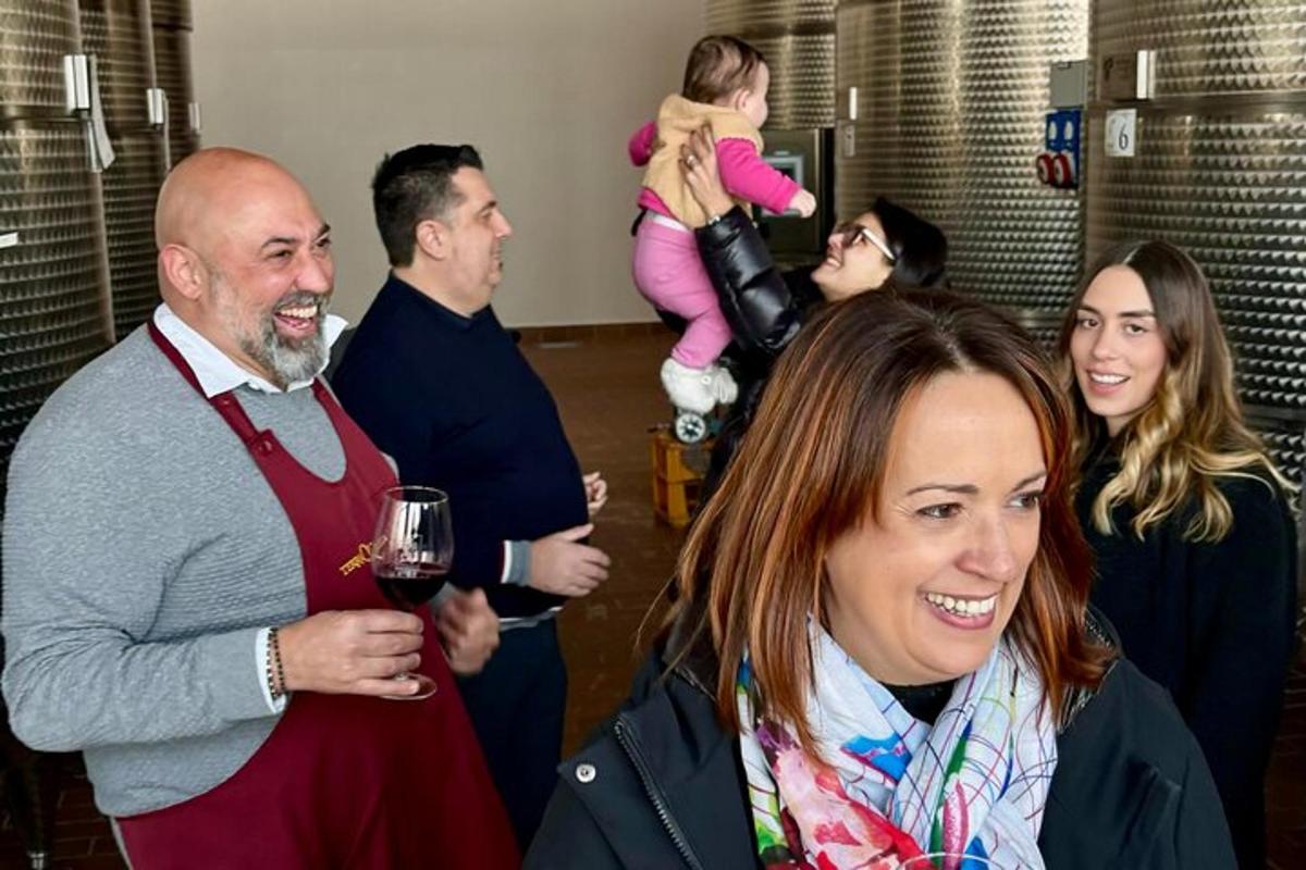 a group of people standing around with a glass of wine