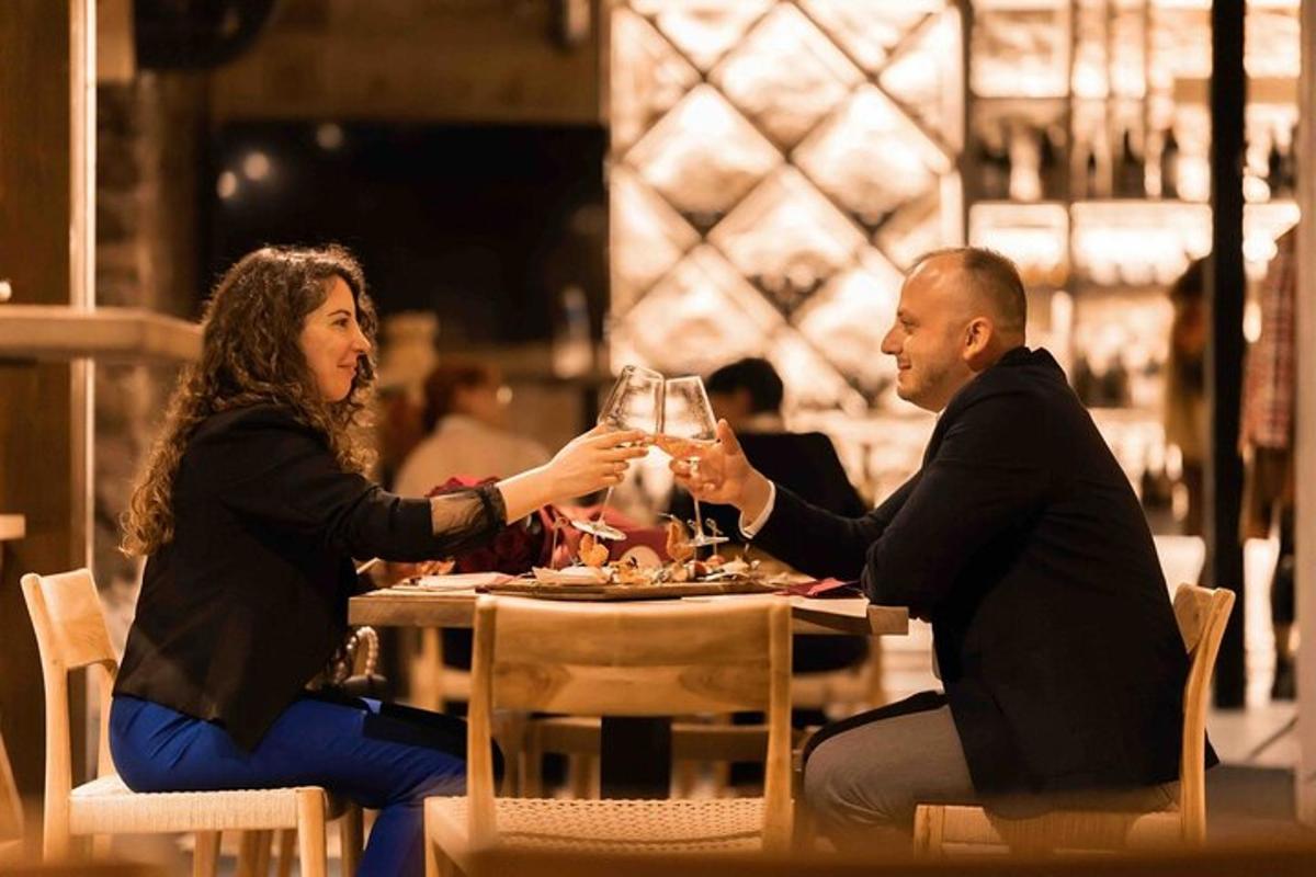 a man and woman sitting at a table with glasses