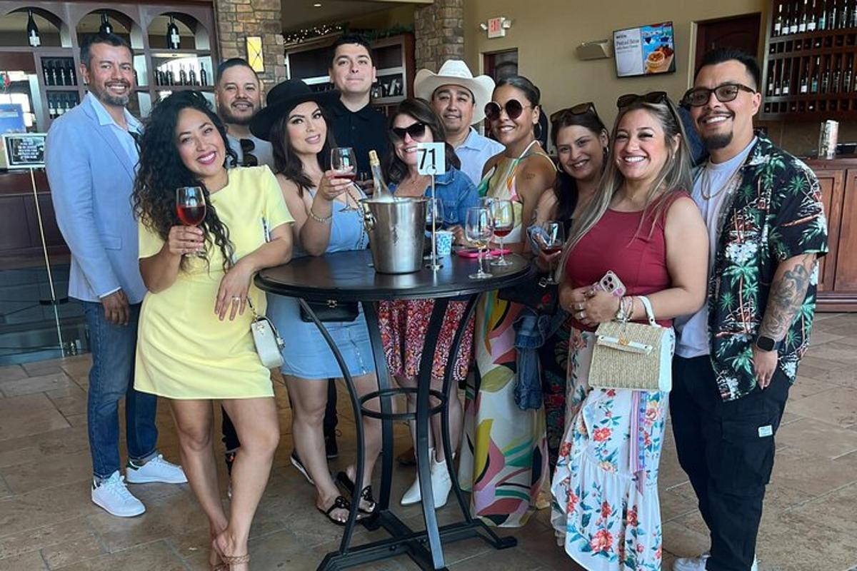 a group of people standing around a table with wine glasses