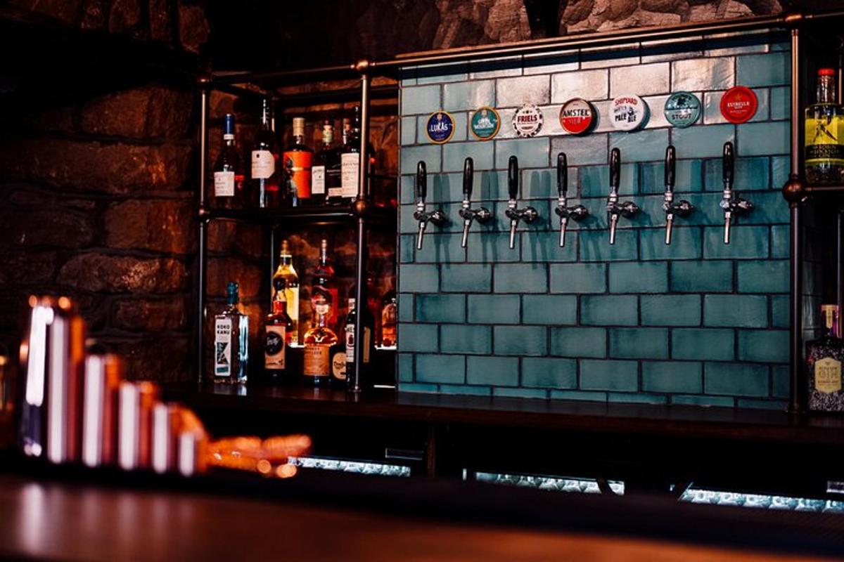 a bar with a tile back wall with alcohol bottles