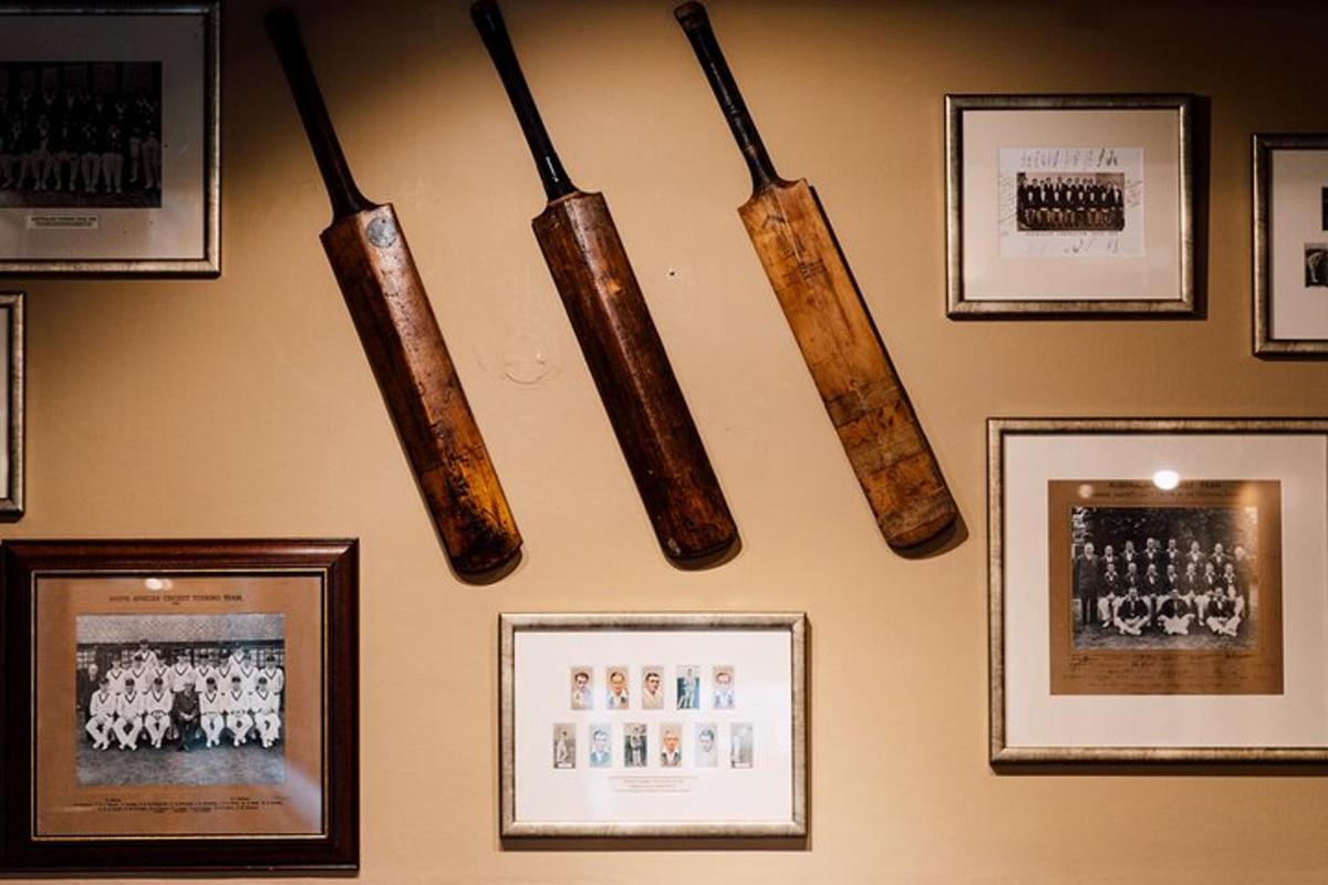 four baseball bats hanging on a wall with framed pictures