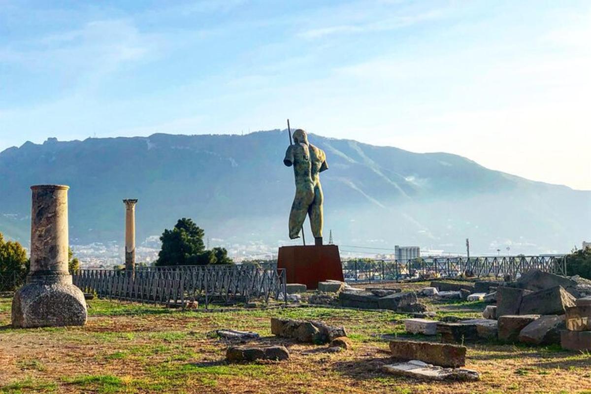 o statuie a unui bărbat care ține o suliță pe un câmp