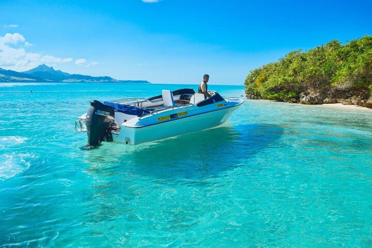 un uomo in piedi nell'acqua accanto a una barca in acqua