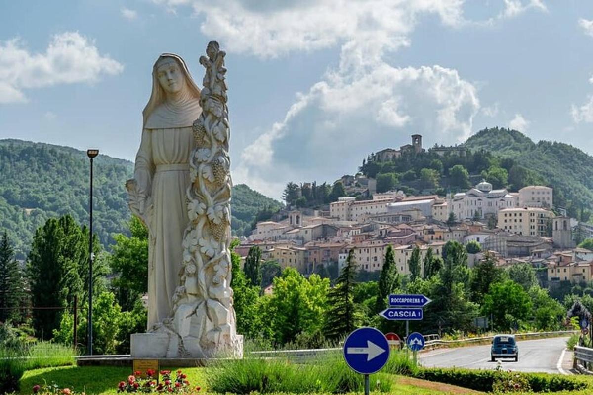 una statua di una donna in piedi accanto a una strada