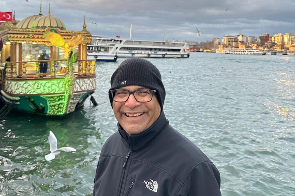 un uomo in piedi davanti a una barca in acqua