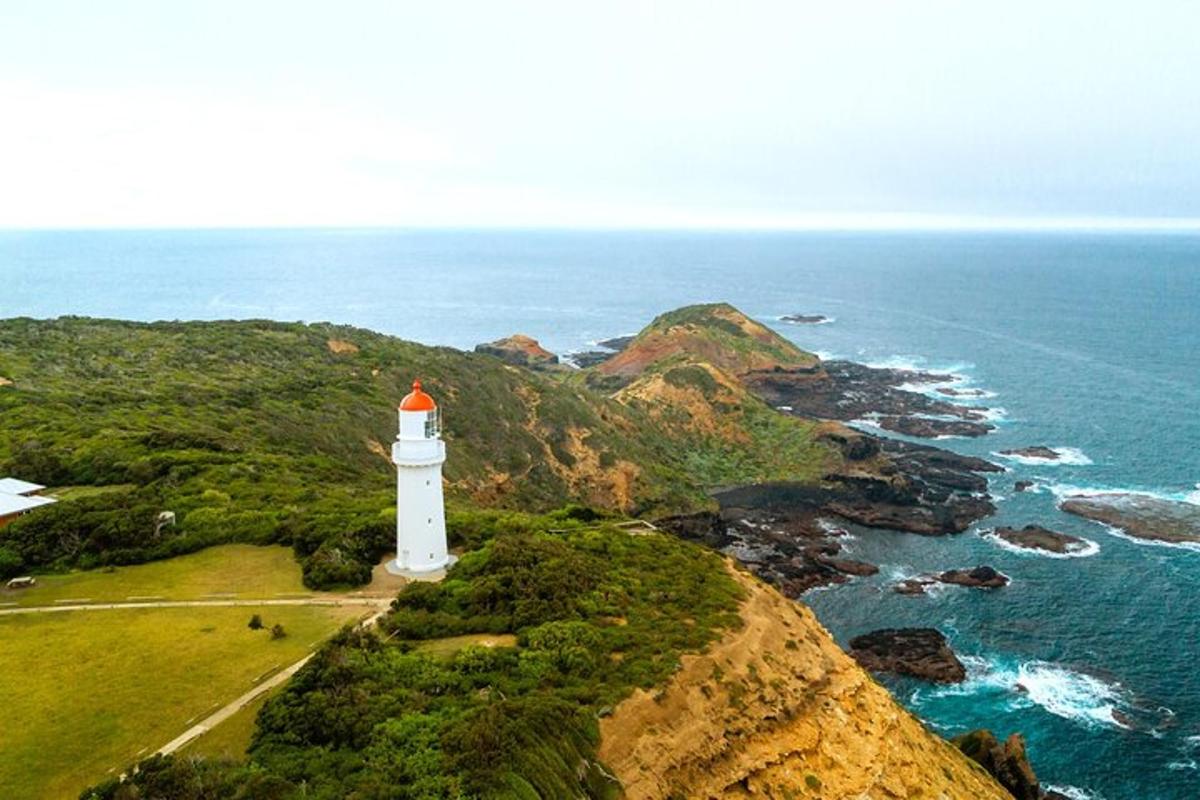 a lighthouse on a cliff next to the ocean