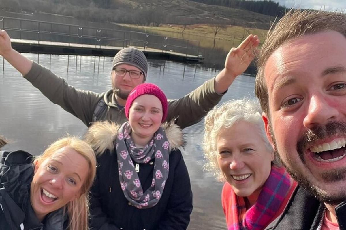 un gruppo di persone in piedi di fronte a uno specchio d'acqua
