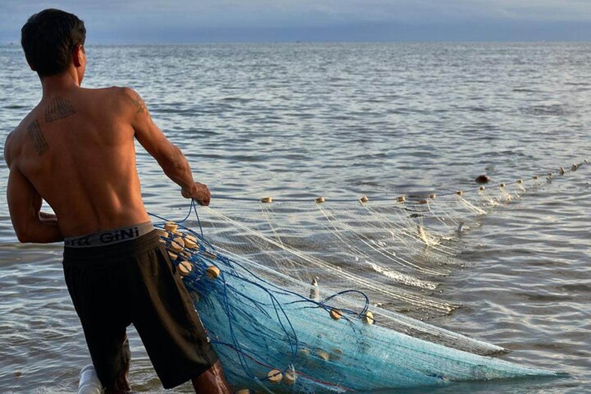 un home dret al costat d'una barca a l'aigua