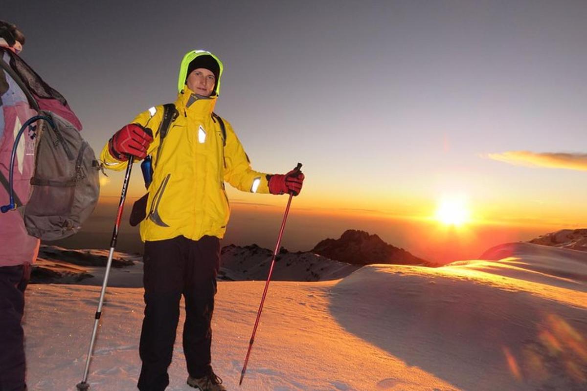Un hombre parado en la cima de una montaña cubierta de nieve