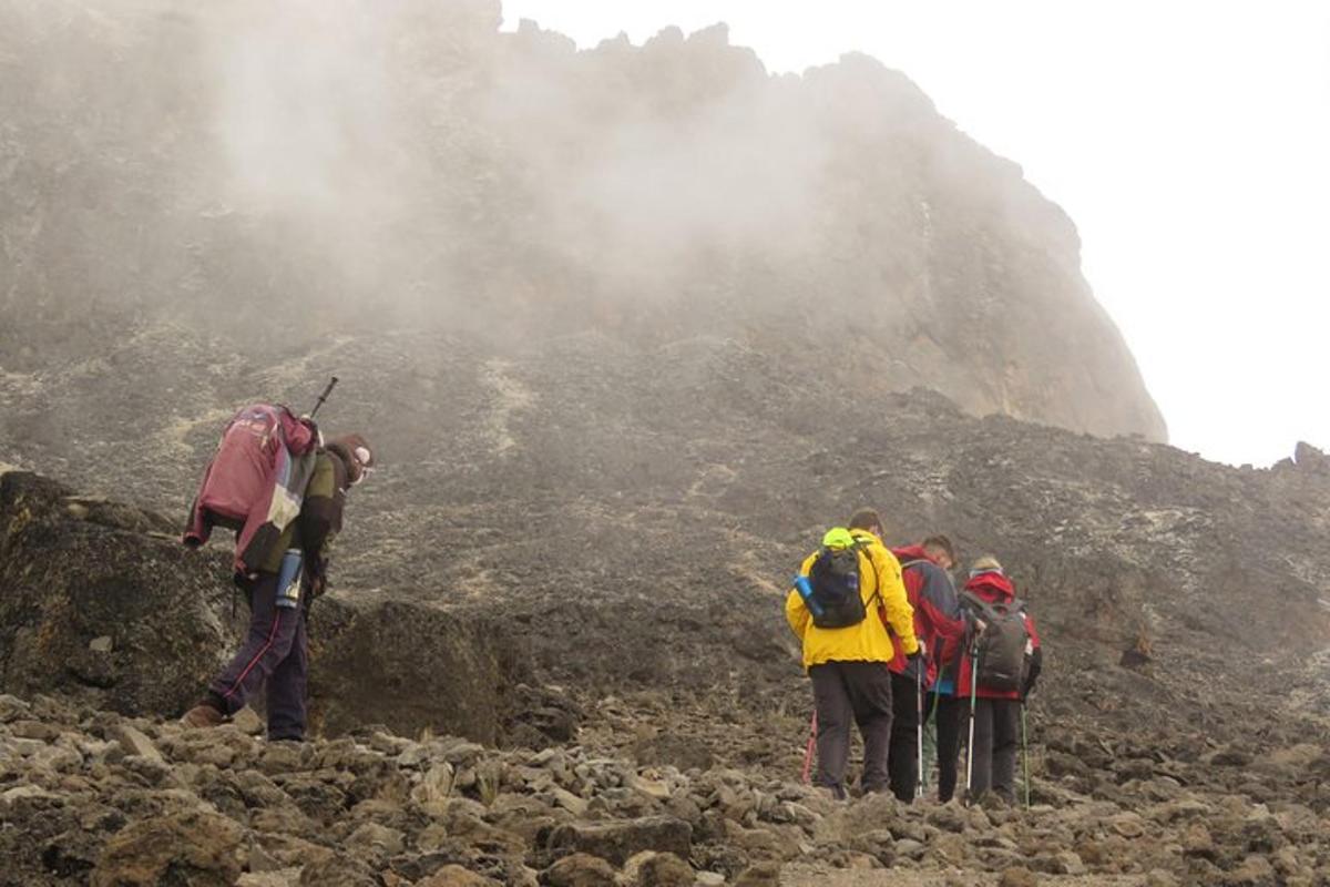 Un grupo de personas de pie en una montaña rocosa
