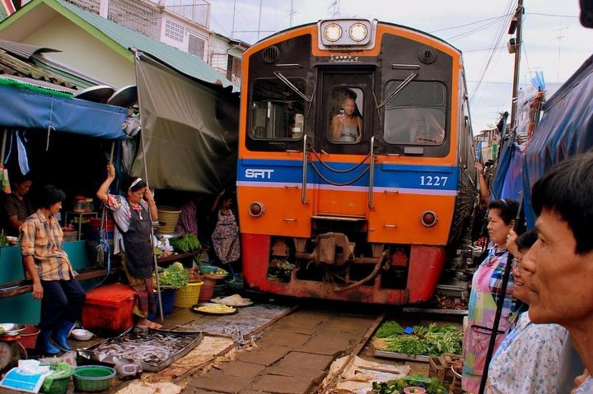 un tren que viatja per un mercat amb gent al voltant