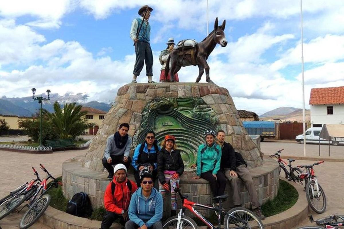 un gruppo di persone in posa davanti a una statua