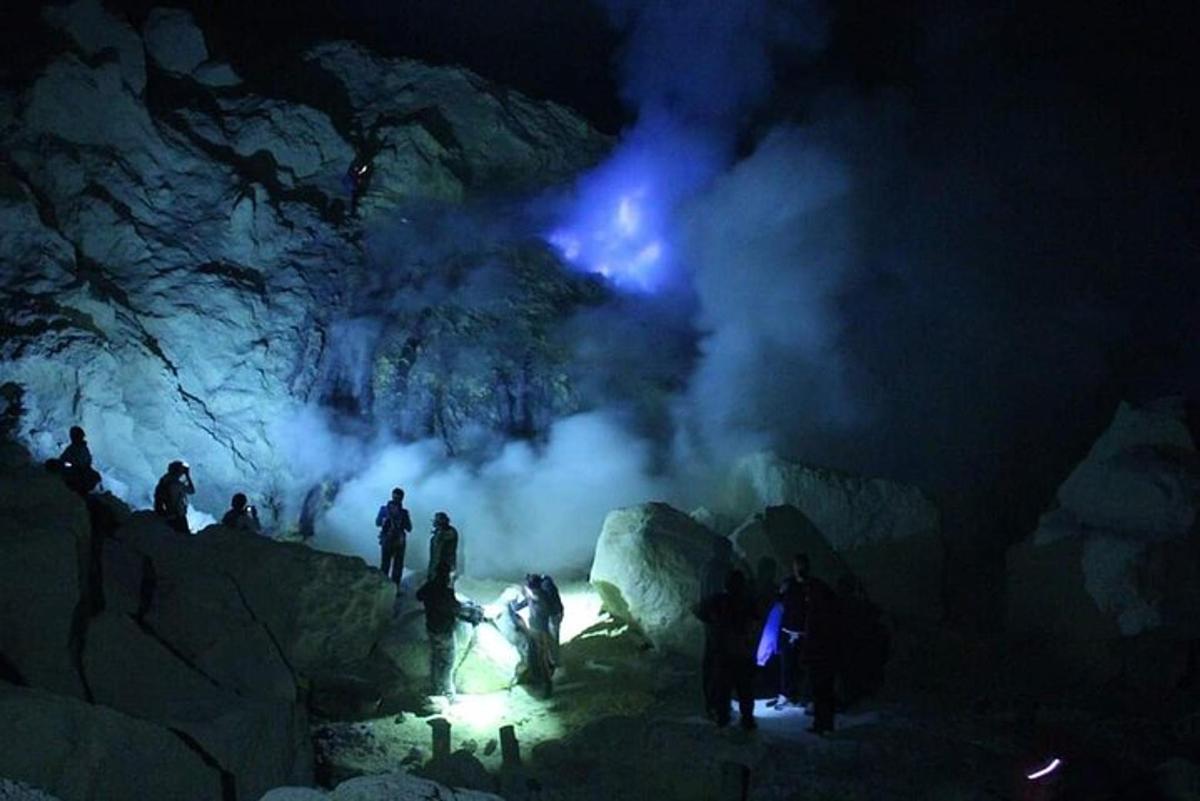 um grupo de pessoas em pé em uma caverna à noite