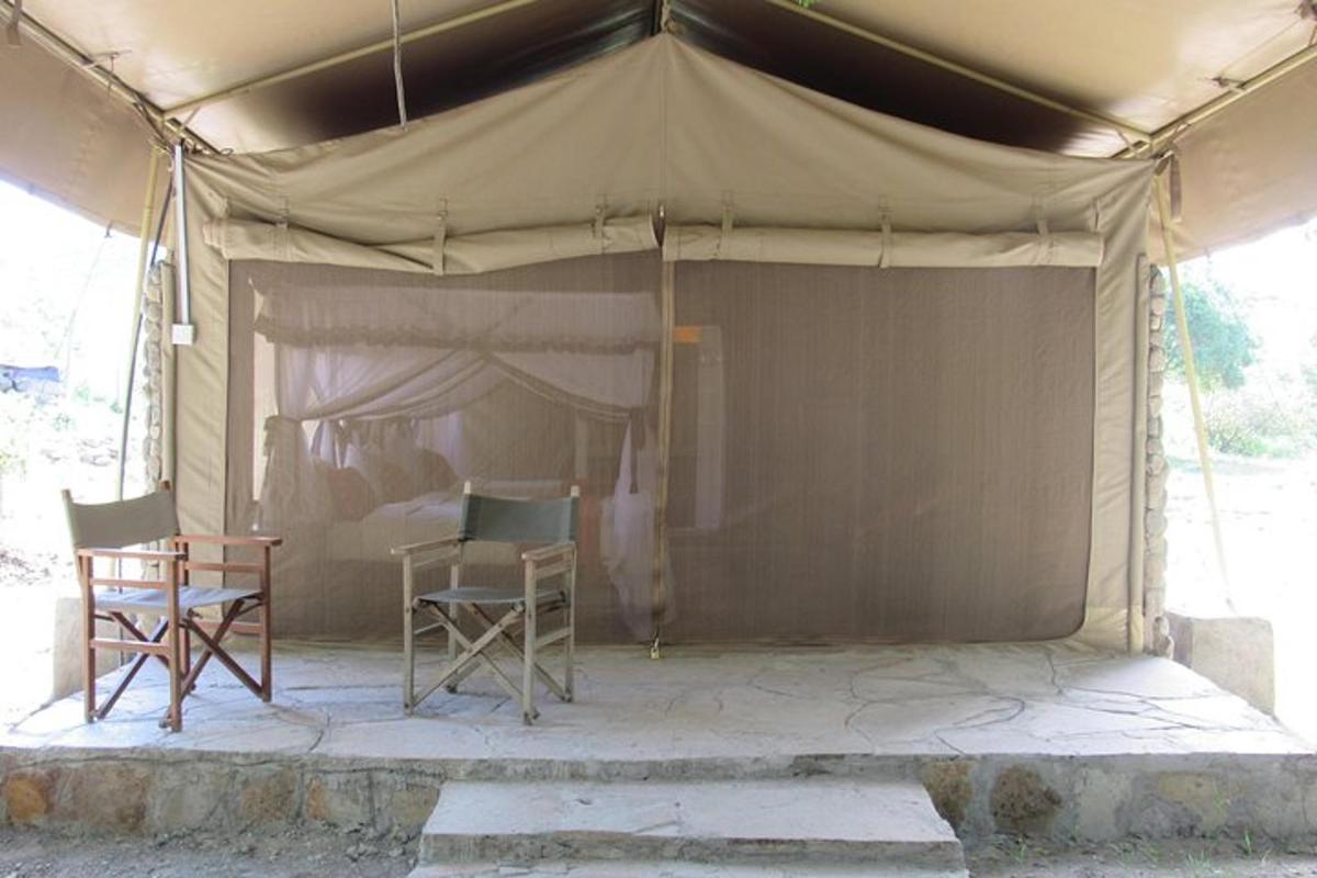 una tenda con due sedie e un tavolo sotto