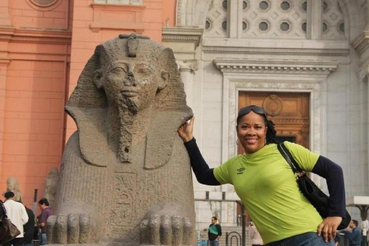 a woman standing next to a statue in front of a building