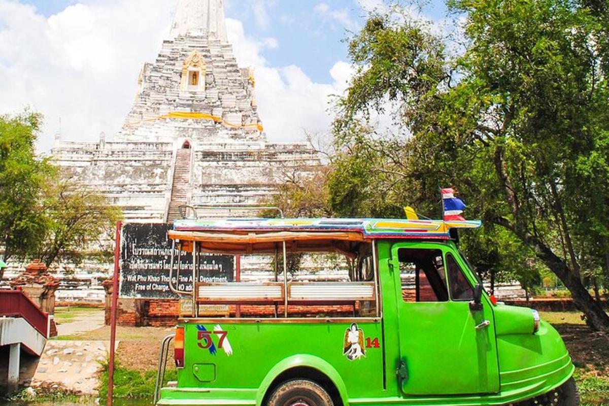 Un camión verde estacionado frente a un templo.