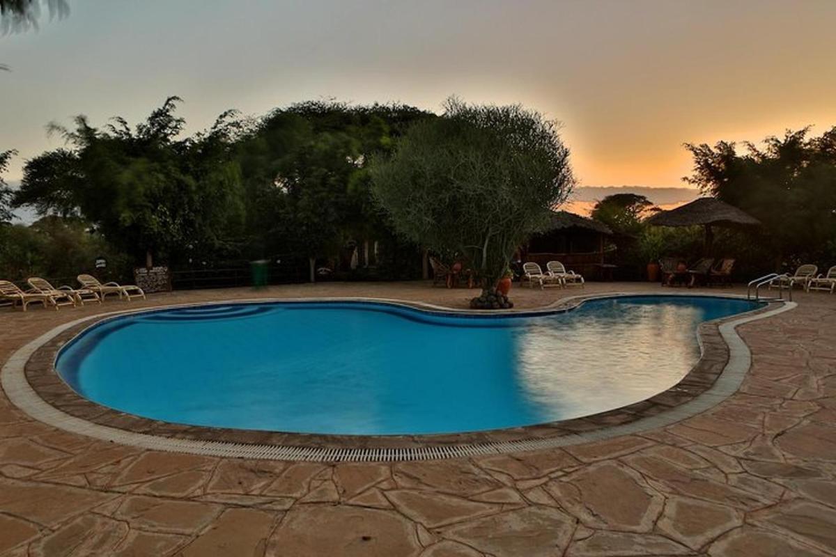 a large swimming pool with a sunset in the background