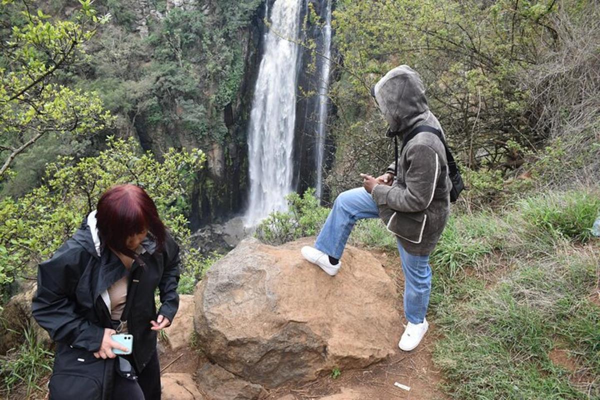 due persone in piedi su una roccia di fronte a una cascata
