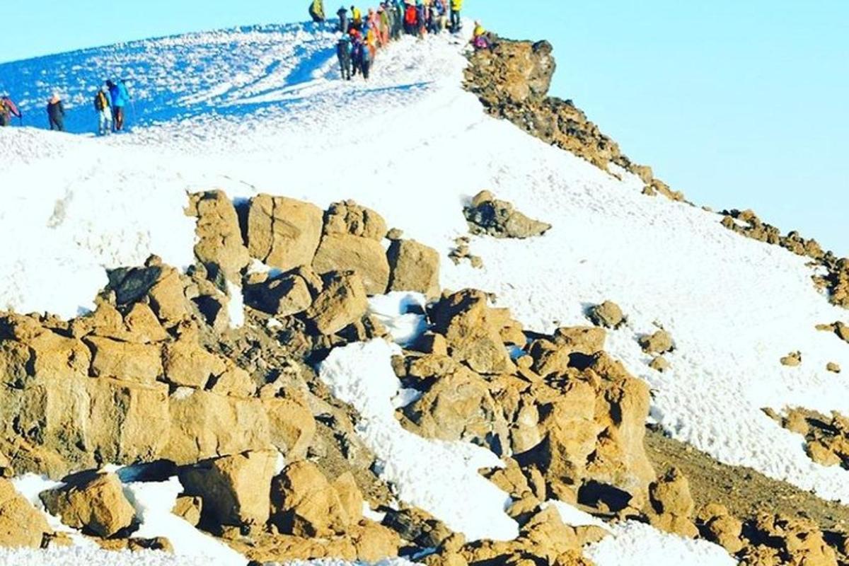 skupina ljudi, ki stojijo na zasneženi gori