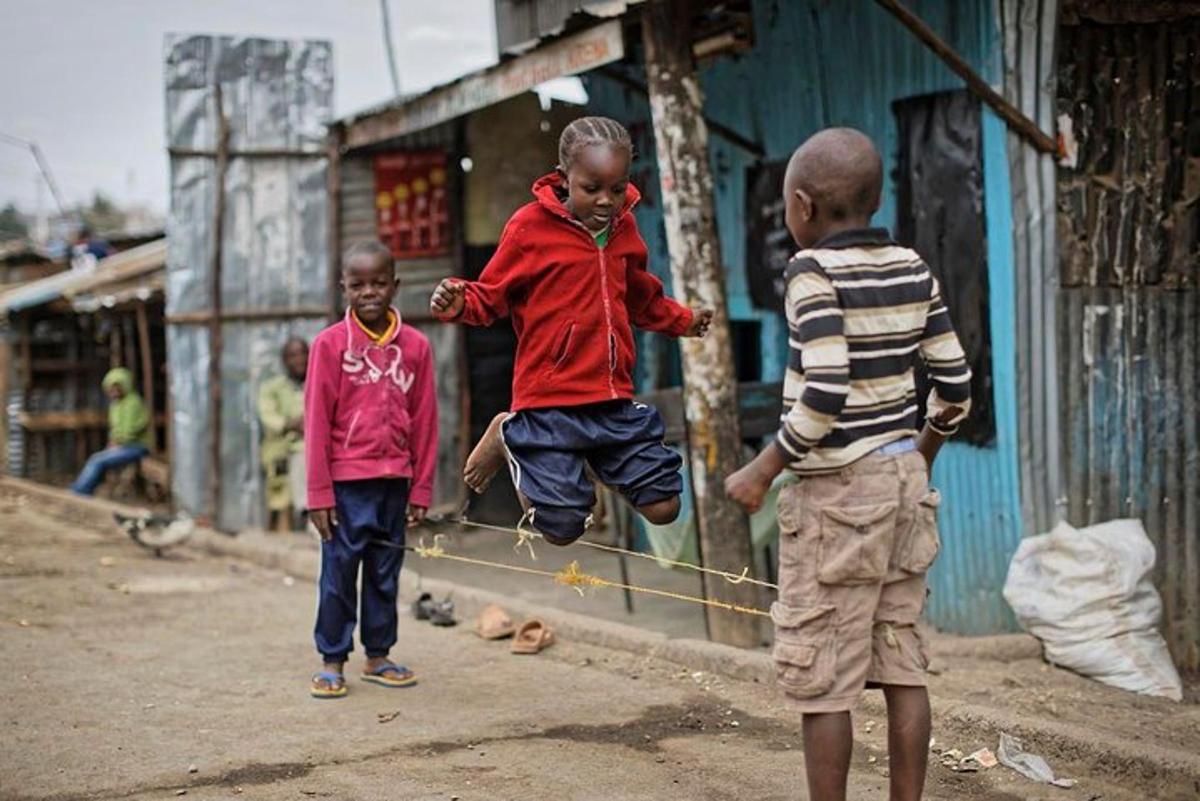 eine Gruppe von Kindern, die auf einer Straße mit einem Ball spielen