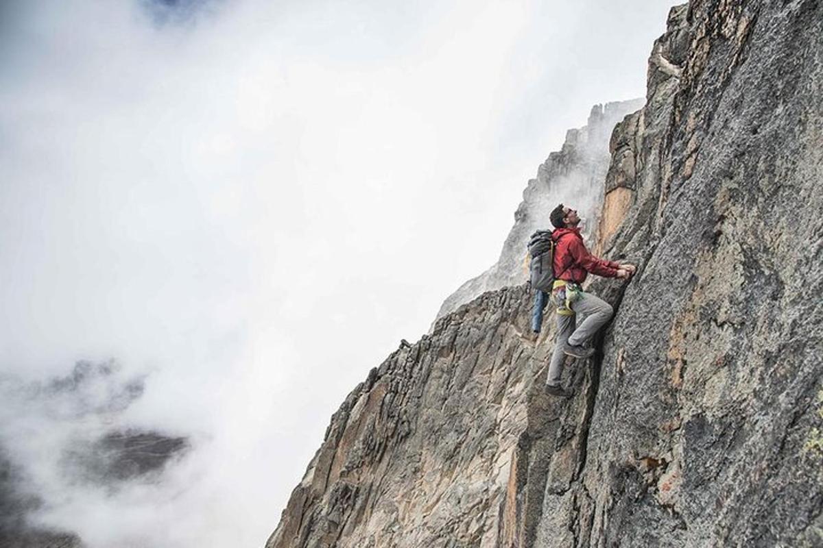 un hombre parado en la ladera de una montaña