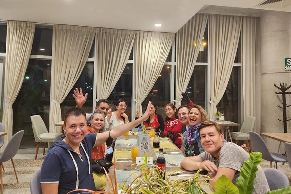 eine Gruppe von Menschen sitzt an einem Tisch und winkt