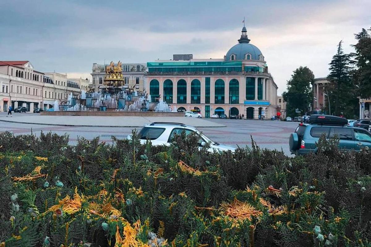 stavba s fontano in avtomobili parkiranimi na parkirišču