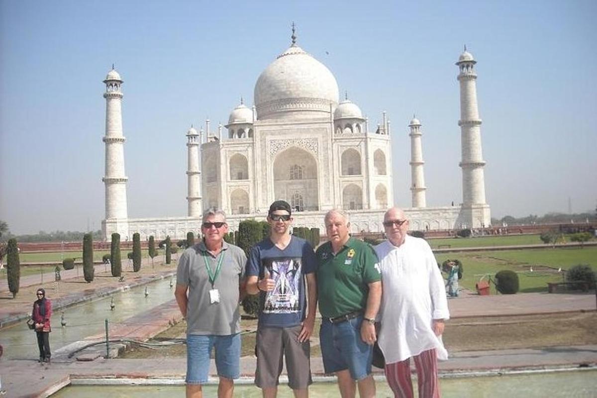 um grupo de pessoas em pé em frente ao Taj Mahal