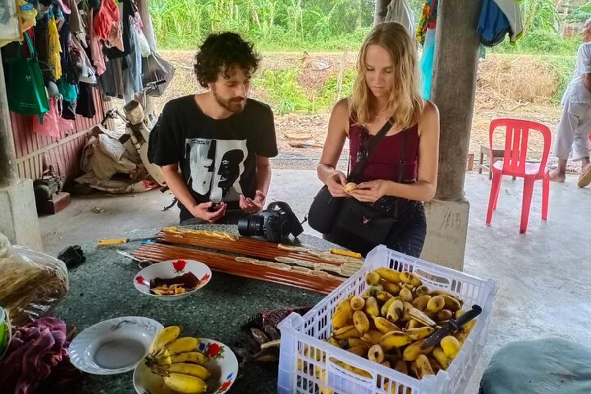 a man and a woman sitting next to a table with bananas