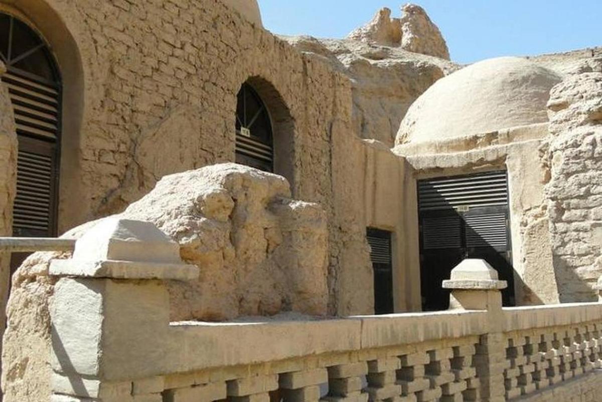 um edifício de pedra com janelas e um muro de pedra