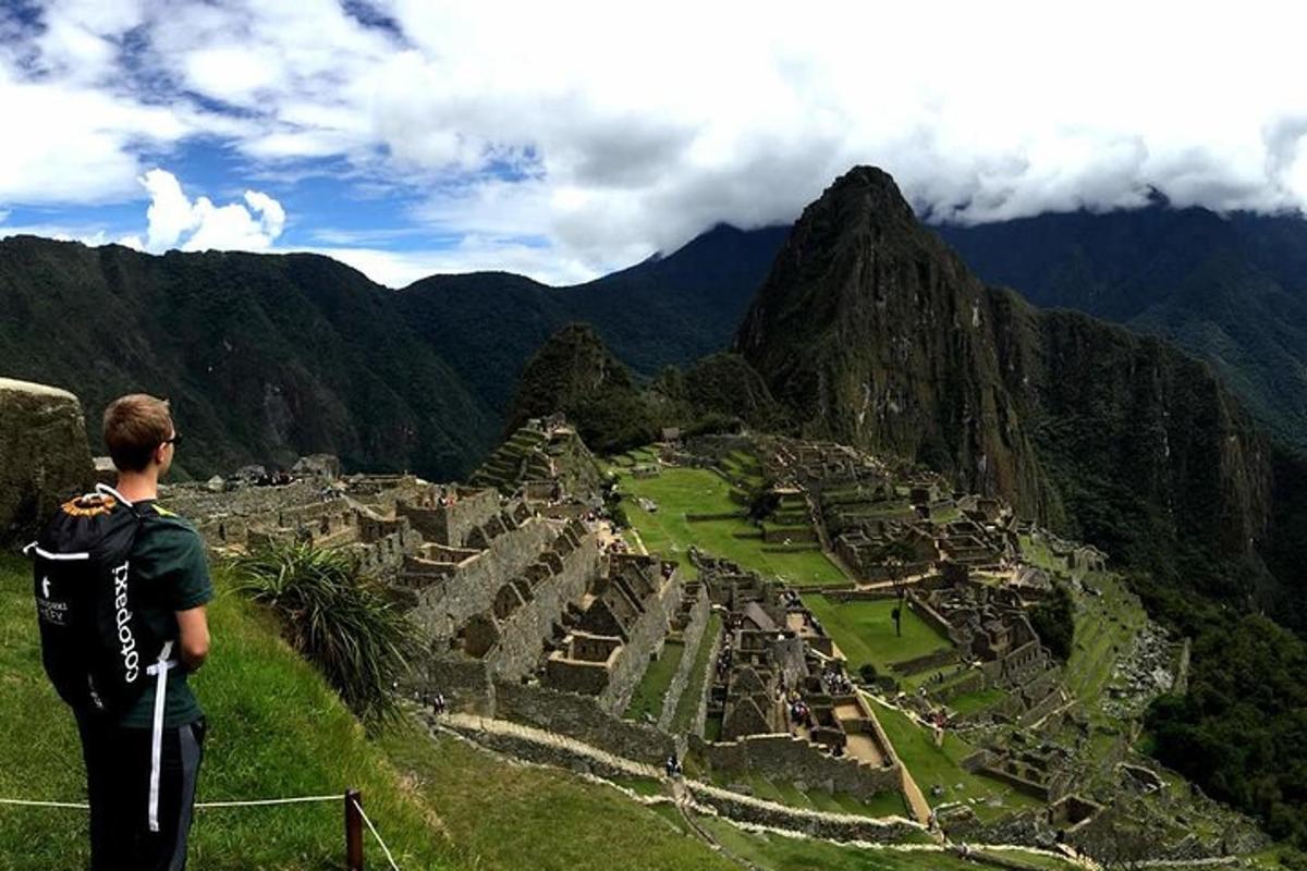 un uomo in piedi sulla cima di una montagna che guarda una città