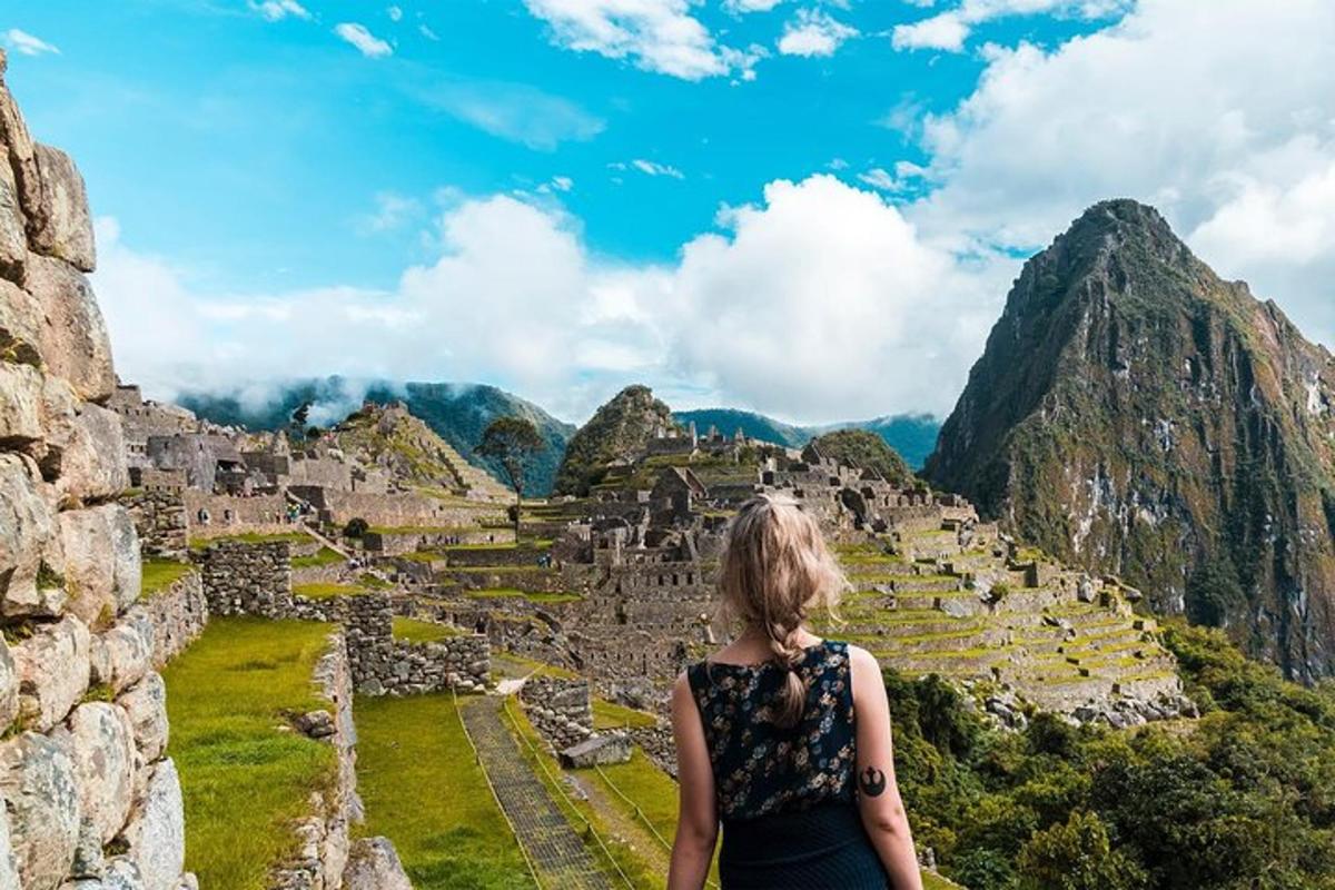 una dona dreta a la part superior de les ruïnes de Machu Picchu