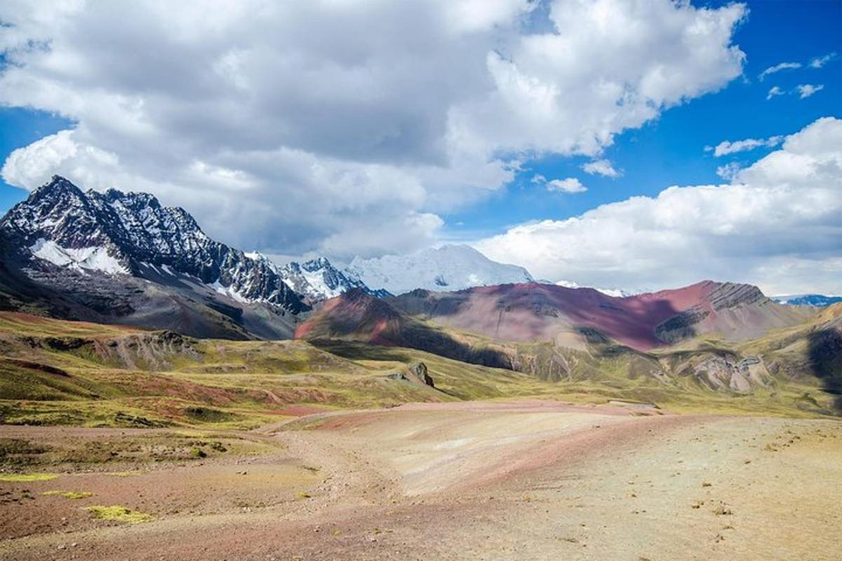 uma cadeia de montanhas com montanhas nevadas e uma estrada de terra