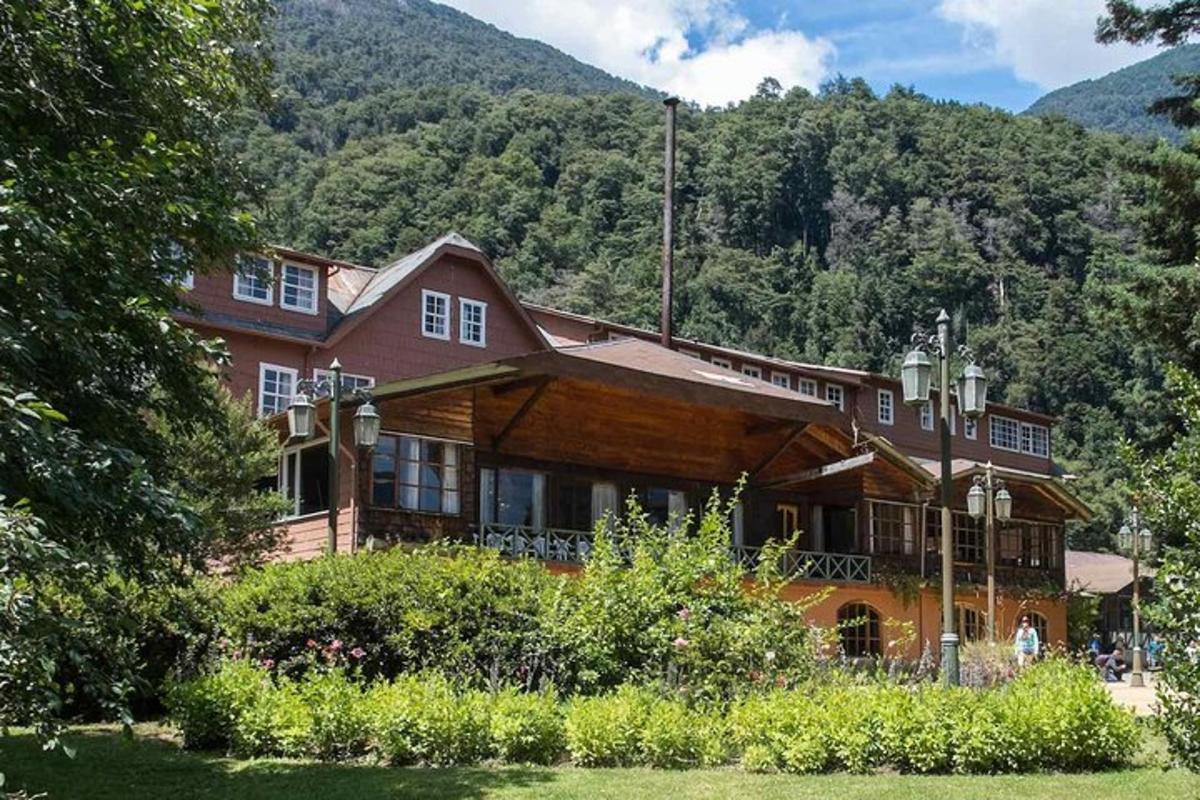 a large wooden house in front of a mountain