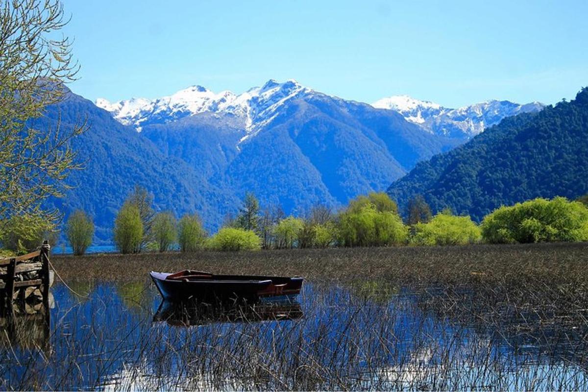 a boat sitting in the water with mountains in the background